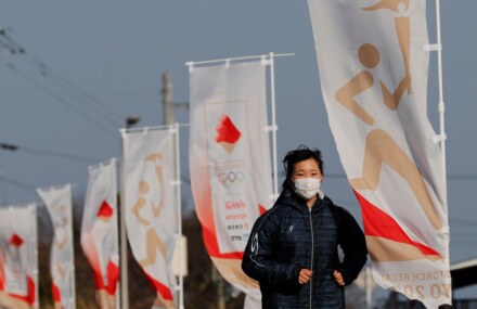 High fives, smiles but no cheers as Olympic torch relay gets going under pandemic shadow